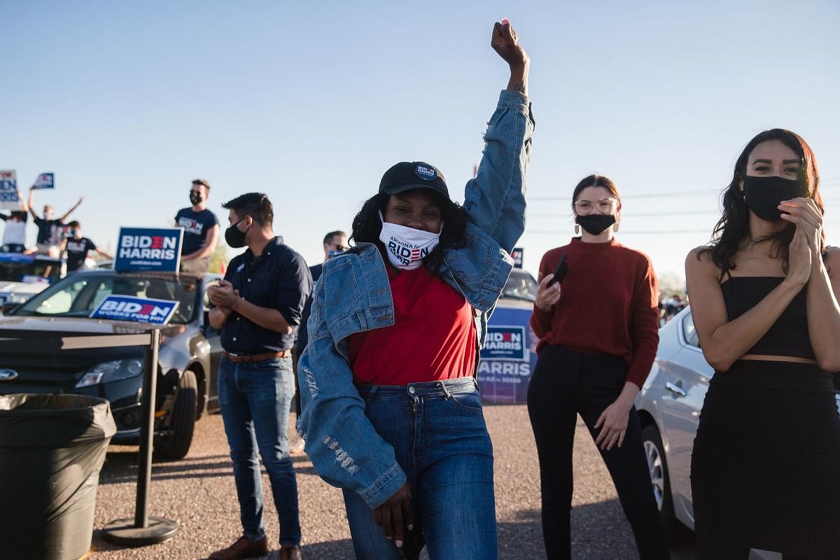 A supporter of Senator from California and Democratic vice presidential nominee Kamala Harris cheers as she attends a drive-in campaign rally in Phoenix, Arizona. Credit: AFP Photo