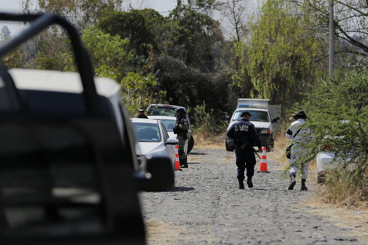 Federal forces guard the perimeter of a site where local authorities work to retrieve bodies from clandestine graves, in Salvatierra, Guanajuato state, Mexico. Credit: Reuters.
