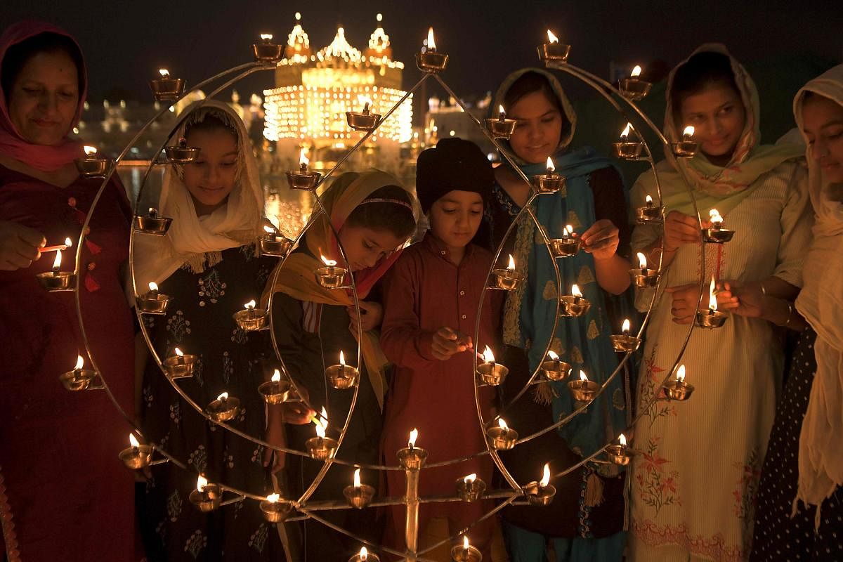 Sikh devotees light candles on the occasion of the birth anniversary of the fourth Sikh Guru Ramdas, at the Golden Temple in Amritsar. Credit: AFP Photo