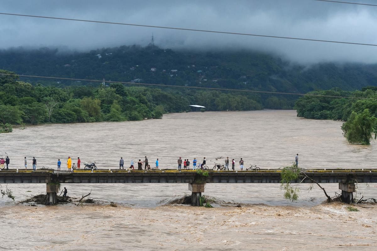 People watch the Humuya river flooding due to heavy rains caused by Eta Hurricane, in Santa Rita, Honduras. Credit: AFP Photo
