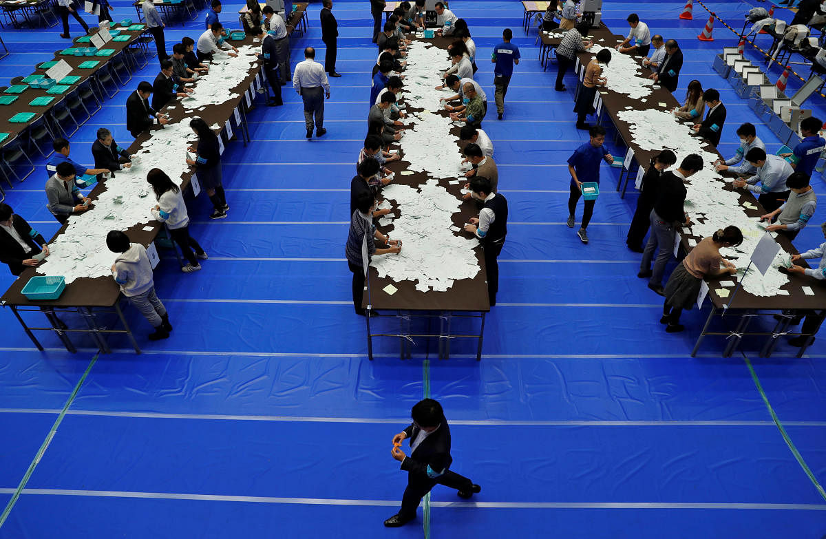 Election officials count votes after Japan's lower house election at a counting centre in Tokyo. Nearly, 53.7% of Japan's registered voters turned up to vote in 2017. Credit: Reuters Photo