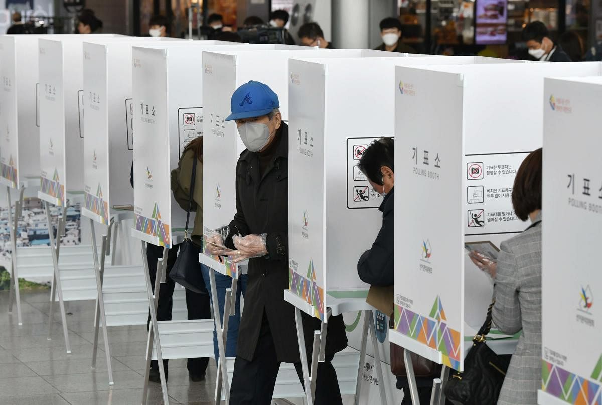 A South Korean man casts a ballot during early voting at a polling station in Seoul. South Korean voter turnout was 77.9% in its 2020 elections. Credit: AFP Photo