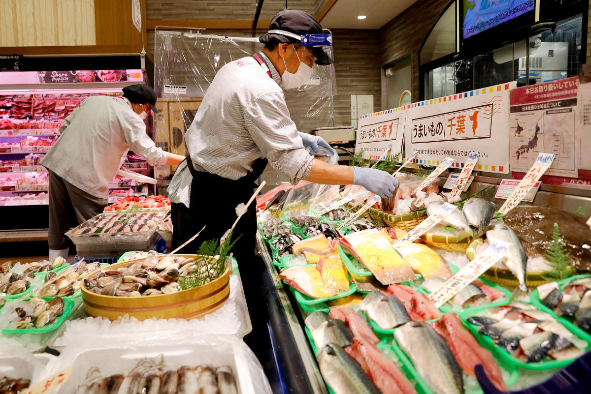 A staff wearing a face shield sells fish at Japan's supermarket group Aeon's shopping mall as the mall reopens amid the coronavirus disease outbreak in Chiba, Japan. Credit: AFP Photo