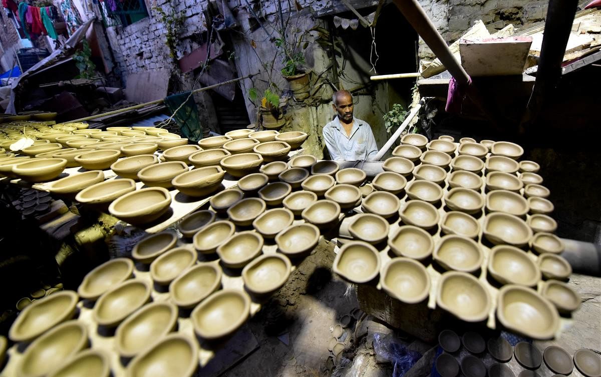A potter makes clay lamps ahead of Diwali festival at Paharganj, in New Delhi. Credit: PTI Photo