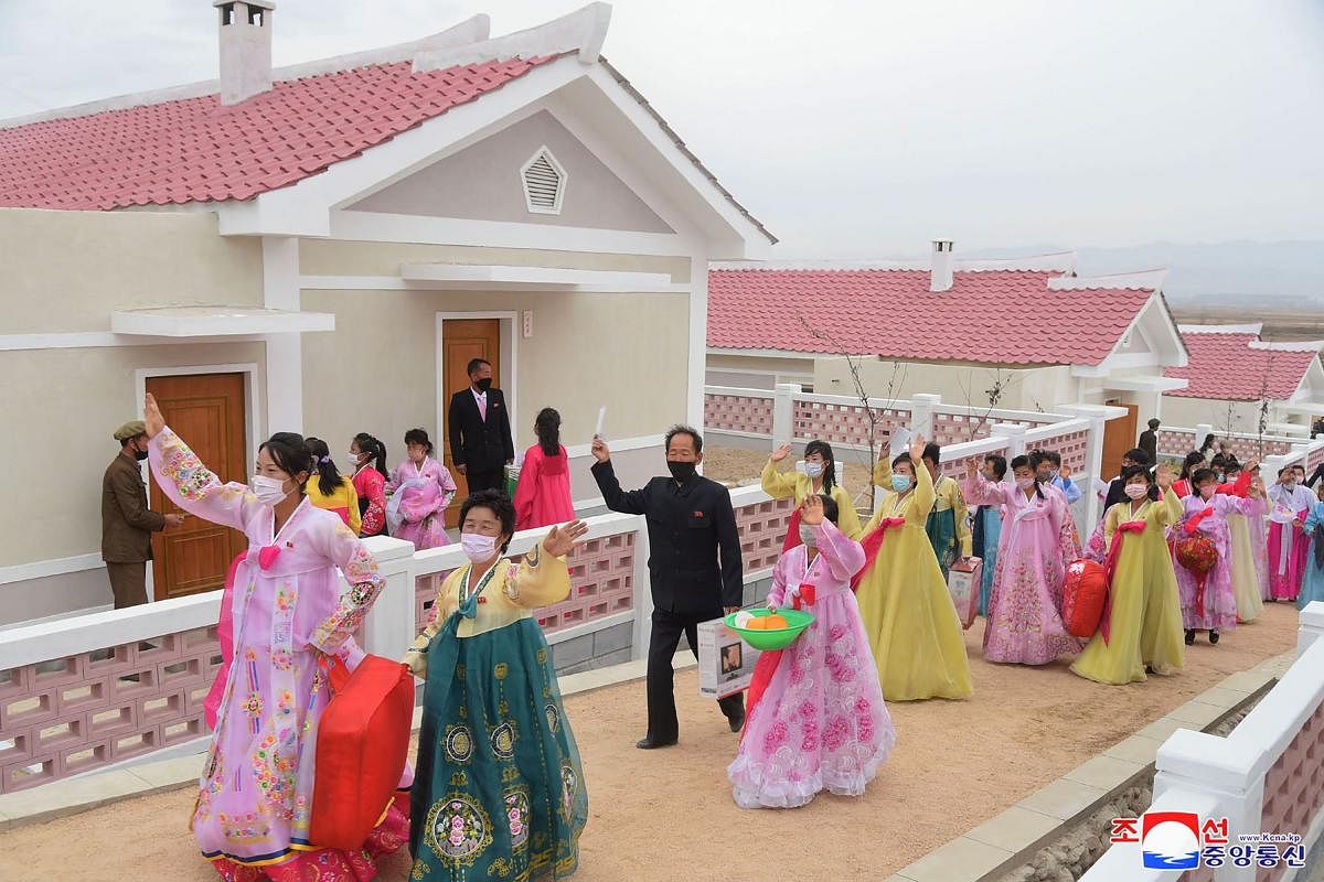 This undated picture released from North Korea's official Korean Central News Agency (KCNA) on November 7, 2020, shows people moving to the newly constructed house in the typhoon stricken area. Credit: KCNA via KNS/AFP Photo