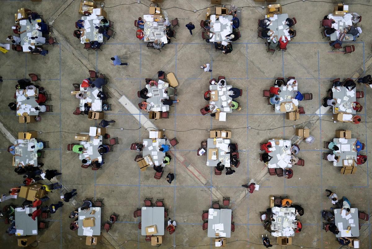 Electoral workers count votes from briefcases with uncounted ballots for the election of local leaders in a tabulation center at the Roberto Clemente Coliseum in San Juan, Puerto Rico. Officials said over 180 briefcases were discovered full of uncounted ballots that were apparently stored in a vault in Puerto Rico and forgotten. Credit: Reuters Photo