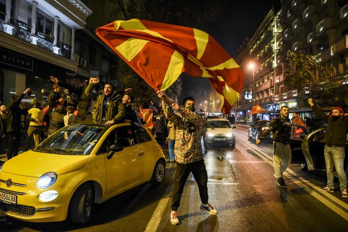 Macedonians supporters wave national flags in a street of Skopje as they celebrate the victory of North Macedonia's team during the UEFA European qualifiers play-off final football match between Georgia and North Macedonia in Tbilisi. Credit: AFP Photo