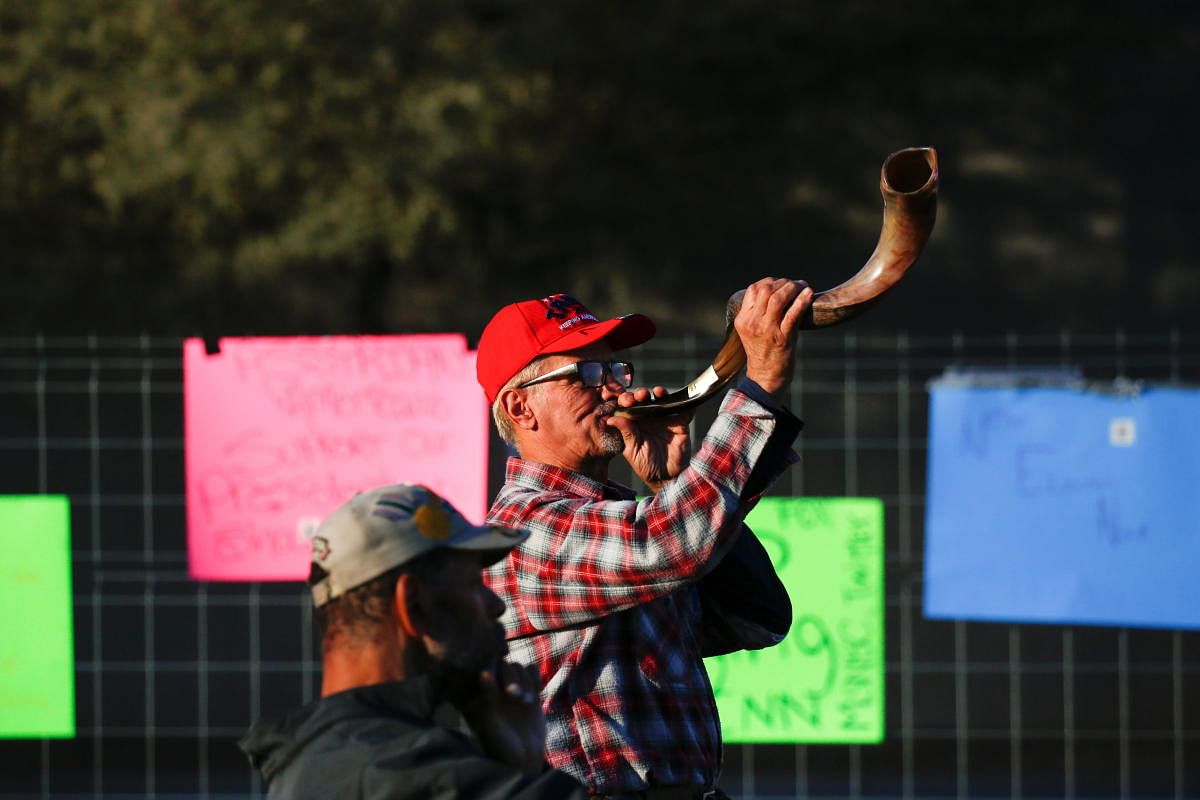 A supporter of US President Donald Trump blows into a shofar during a