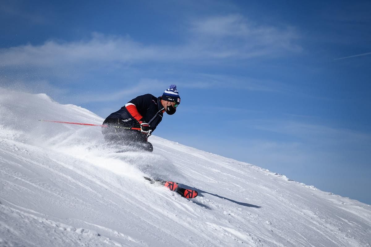 Former alpine skiing Olympic champion Didier Defago, wearing a protective face mask against the spread of the Covid-19 skis a slope above the resort of Verbier in the Swiss Alps. The coronavirus crisis shuttered Switzerland's ski resorts in the spring, but they are banking on tighter precautions and the Swiss love of the mountains to save them as the winter season begins. Credit: AFP Photo