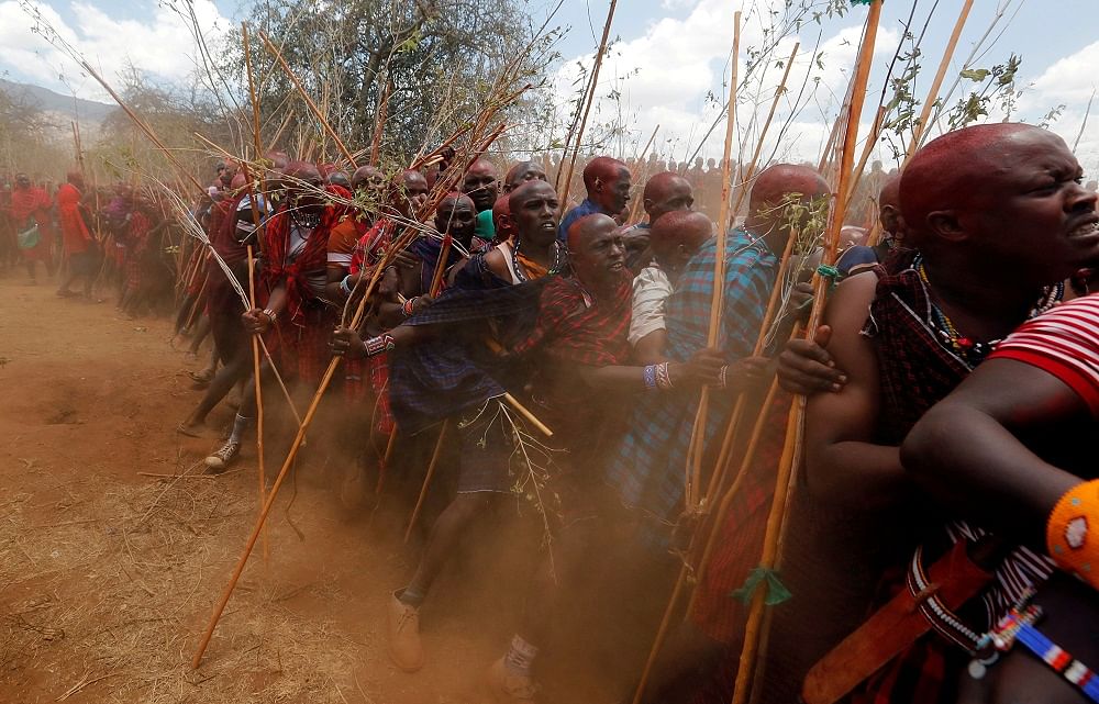 Maasai men of Matapato jostle to parade as they attend the Olng'esherr (meat-eating) passage ceremony to unite two age-sets; the older Ilpaamu and the younger Ilaitete into senior elder-hood as the final rite of passage, after the event was initially postponed due to the coronavirus. Credit: Reuters Photo