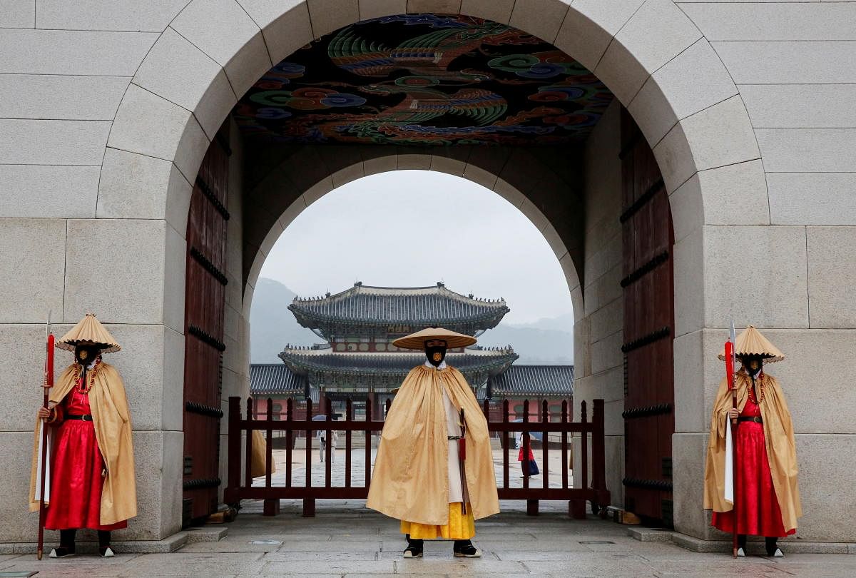 Workers wearing traditional attire wear masks to prevent the spread of the coronavirus during the daily re-enactment of the changing of the Royal Guards at Gyeongbok Palace in central Seoul, South Korea. Credit: Reuters Photo