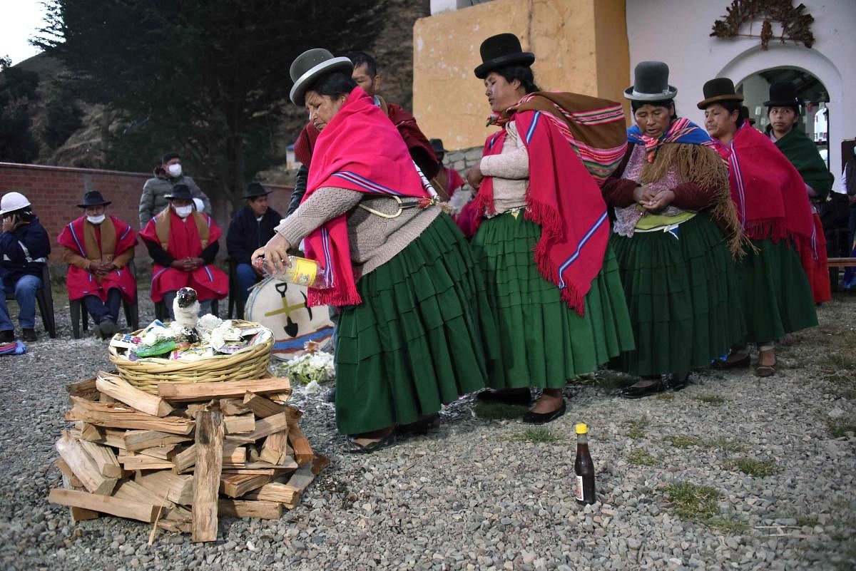 Indigenous women take part in an ancestral ritual to ask Achachilas (mountains) and Pachamama (mother earth) for rain in agriculture lands in Hampaturi, 30 Km northeast of La Paz, Bolivia, where the dam that supplies the capital of water is located. Credit AFP Photo