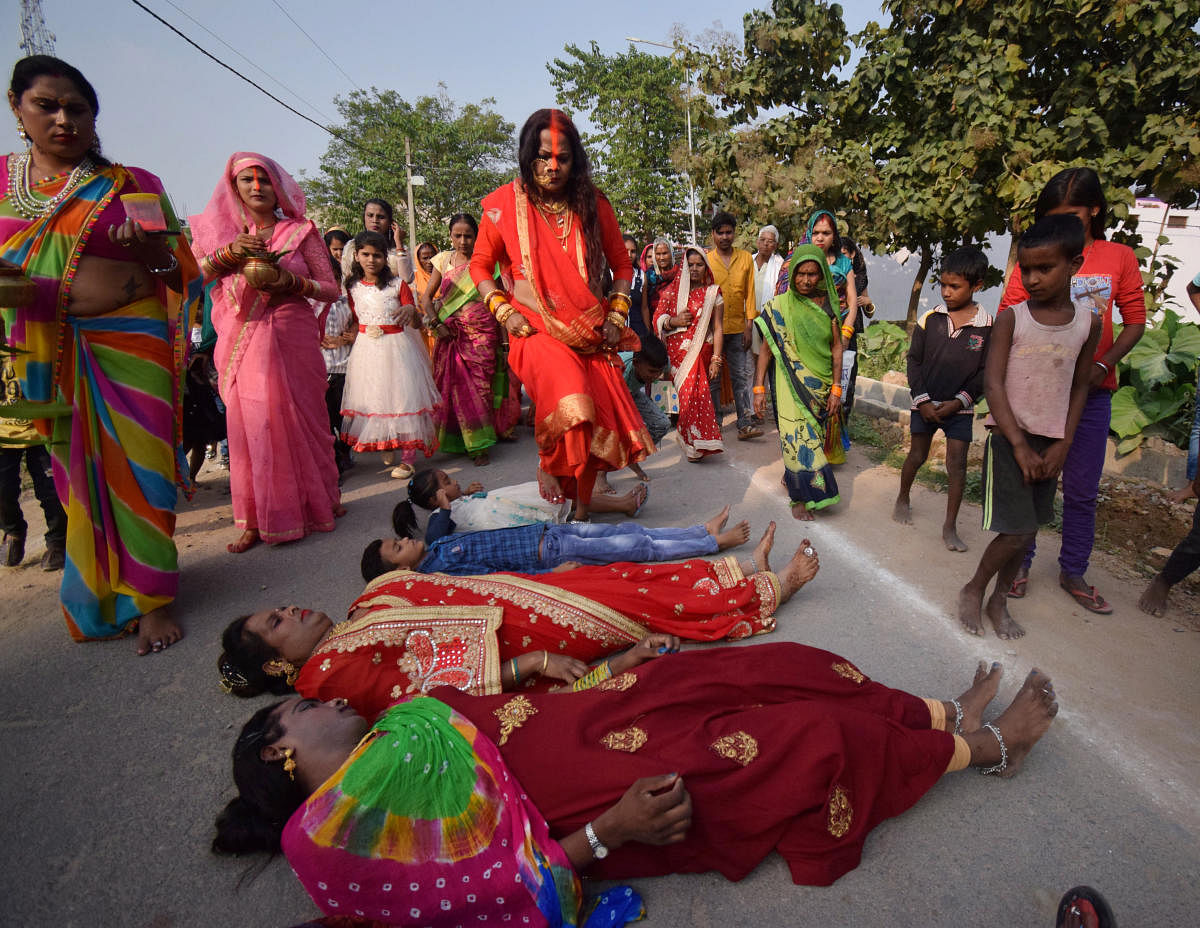 A Kinnar Akhada member performs rituals with other devotees during Chhath Puja, in Gorakhpur. Credit: PTI Photo