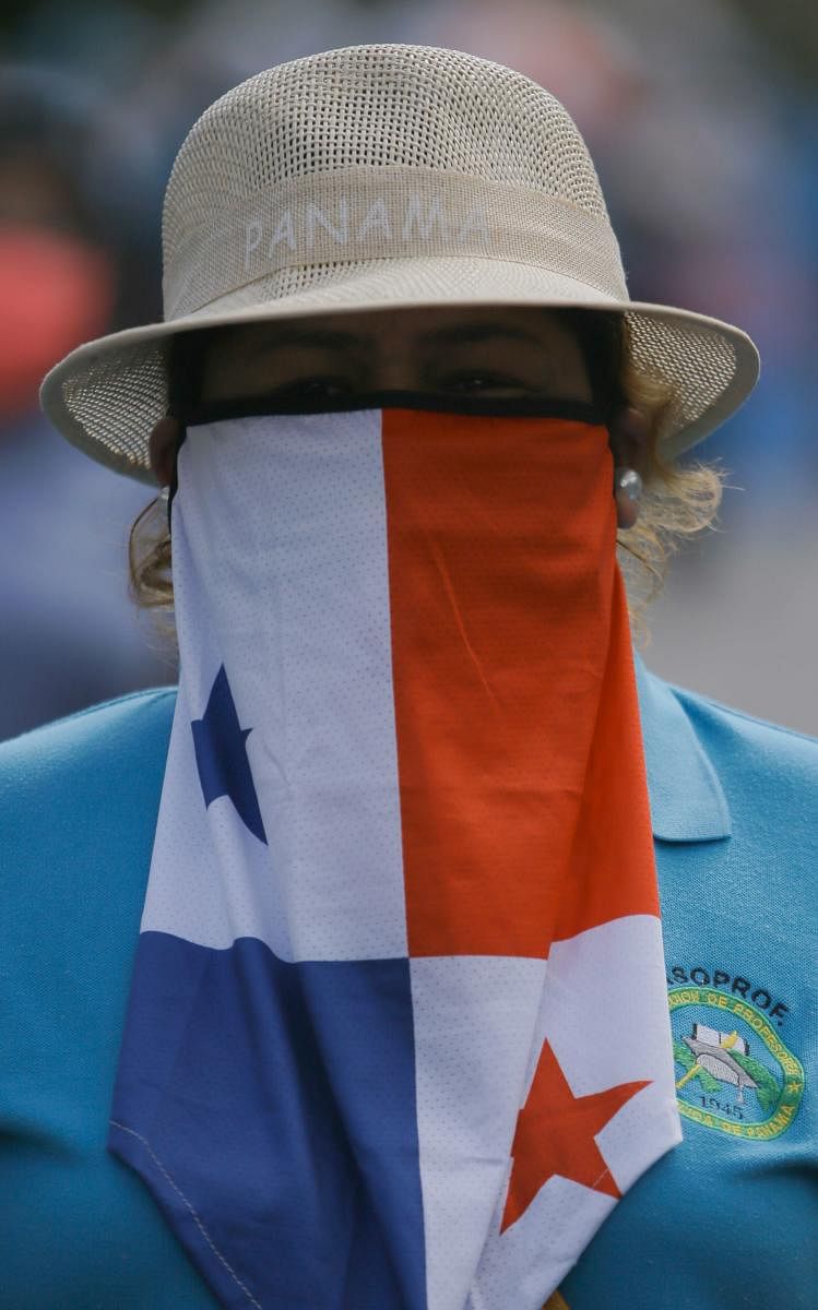 An educator with a Panamanian flag on her face takes part in a protest demanding better education conditions in Panama City. Educational unions demonstrated to commemorate the International day of Children's rights denouncing the alleged violation of the right to education during the school year where virtual clases, due to the Covid-19 pandemic, did not reach to all students. Credit: AFP Photo