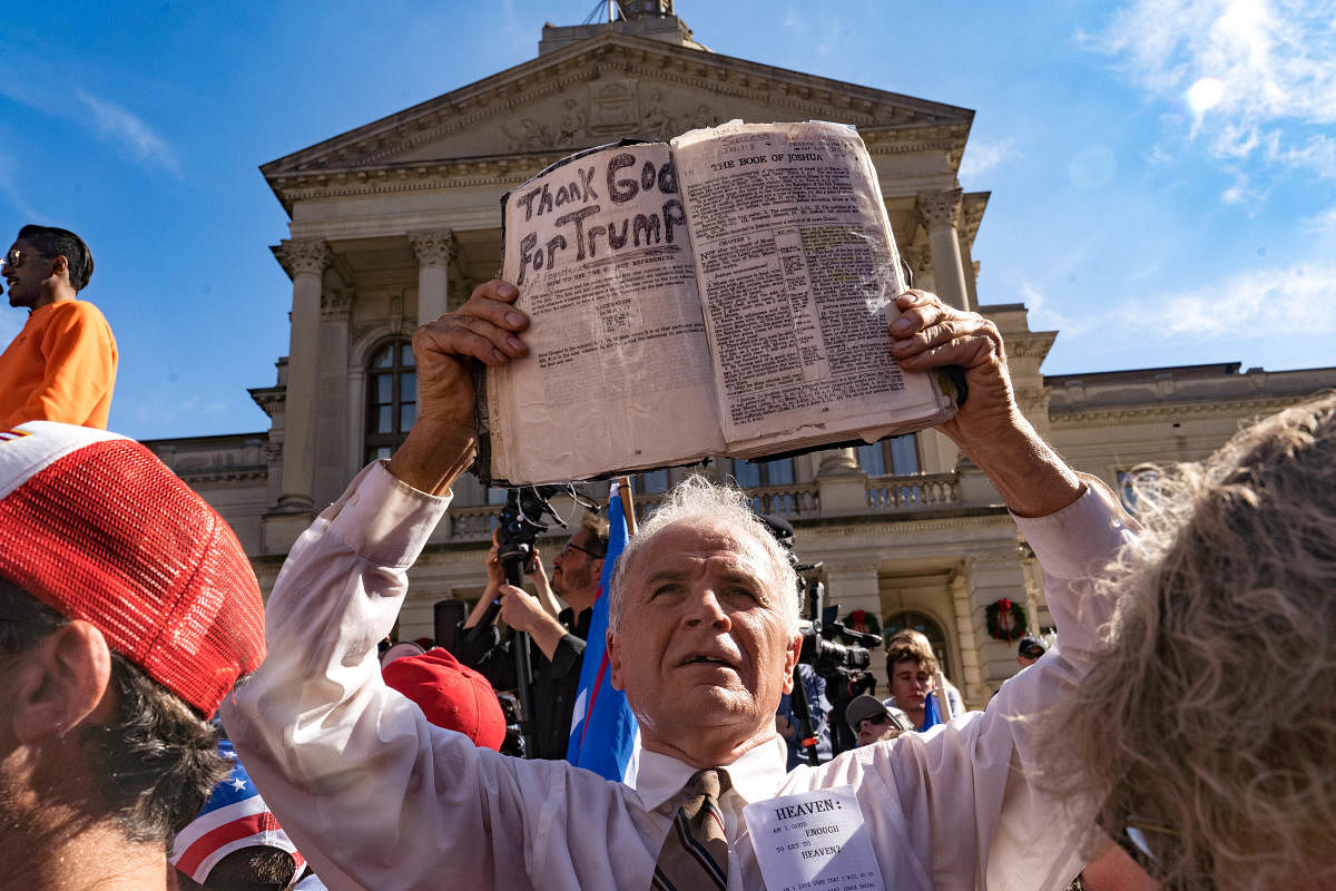 A preacher holds up his Bible while supporters of Donald Trump host a Stop the Steal protest outside of the Georgia State Capital building. Credit: AFP Photo
