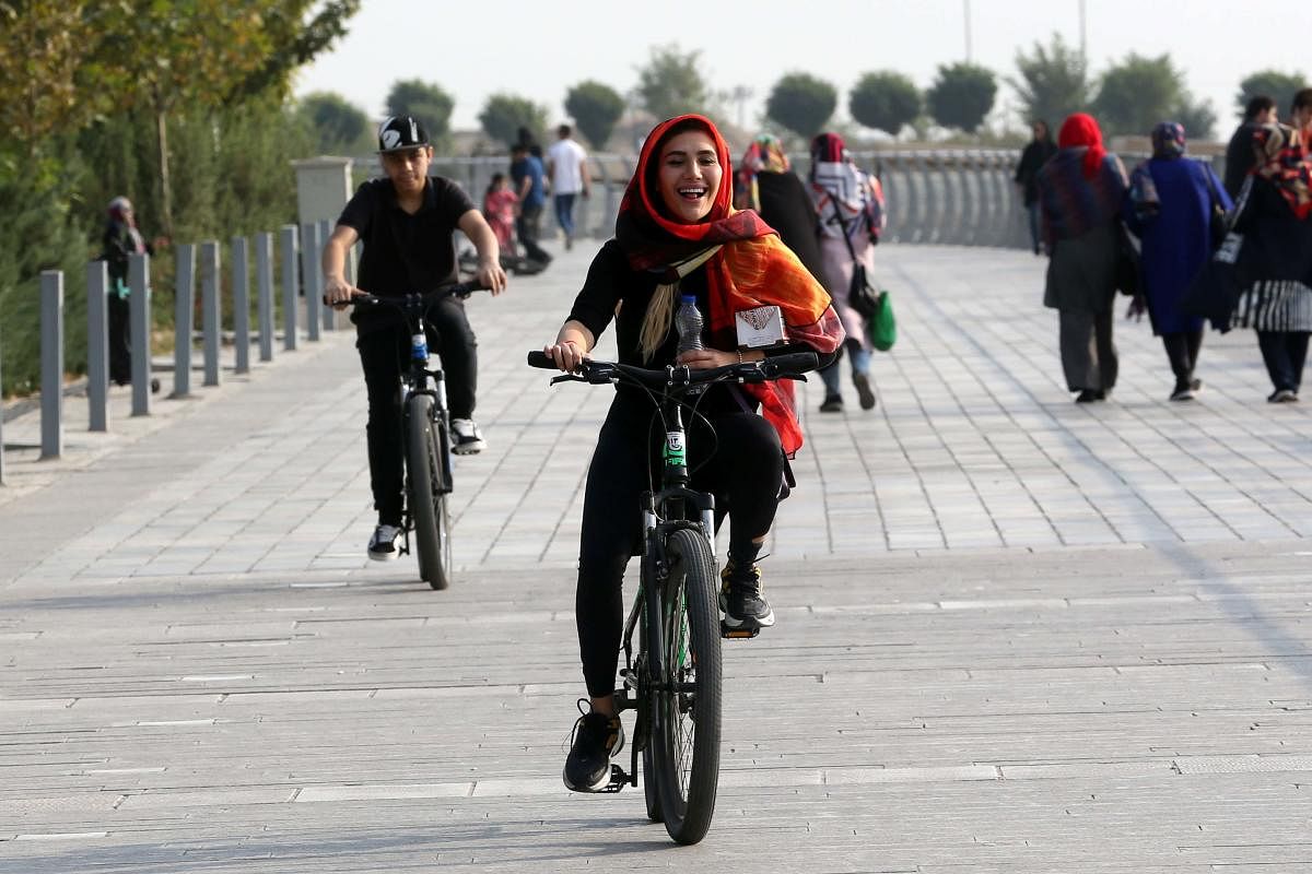 An Iranian woman rides a bicycle around the artificial Chitgar lake in the capital Tehran. The metropolis of over eight million at the foothills of the Alborz mountains is choked with vehicles running on subsidised fuel and has limited infrastructure for alternative modes of transportation. But its mayor believes trying to make a dent in the city's traffic and pollution problem by promoting a bike-sharing initiative is worth the effort. Credit: AFP Photo