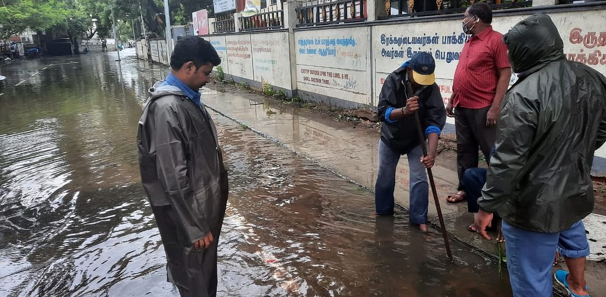 Workers from the civic body clearing a waterlogged road in Vepery in Chennai. Credit: DH Photo