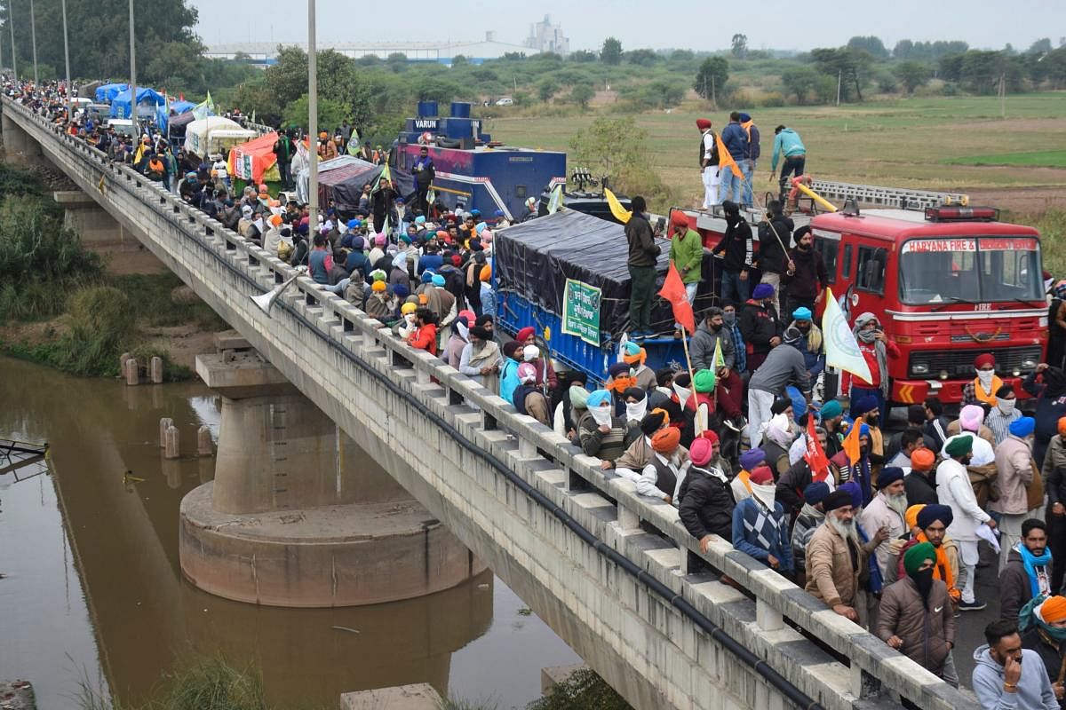 Farmers gather on a bridge as police block a road during a march to India's capital New Delhi to protest against the central government's recent agricultural reforms, on the outskirts of Ambala on November 26, 2020. Credit: AFP Photo