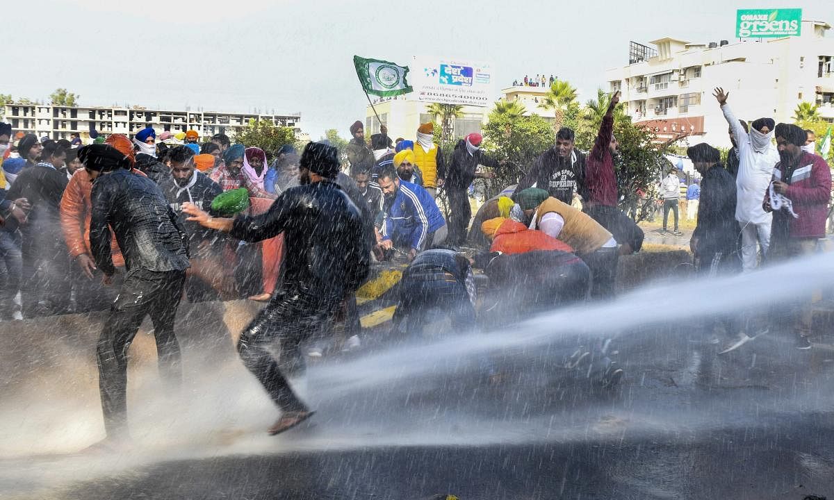 Police personnel use water canons on farmers to stop them from crossing the Punjab-Haryana border during 'Delhi Chalo' protest march against the new farm laws, near Ambala, Thursday, Nov. 26, 2020. Credit: PTI Photo