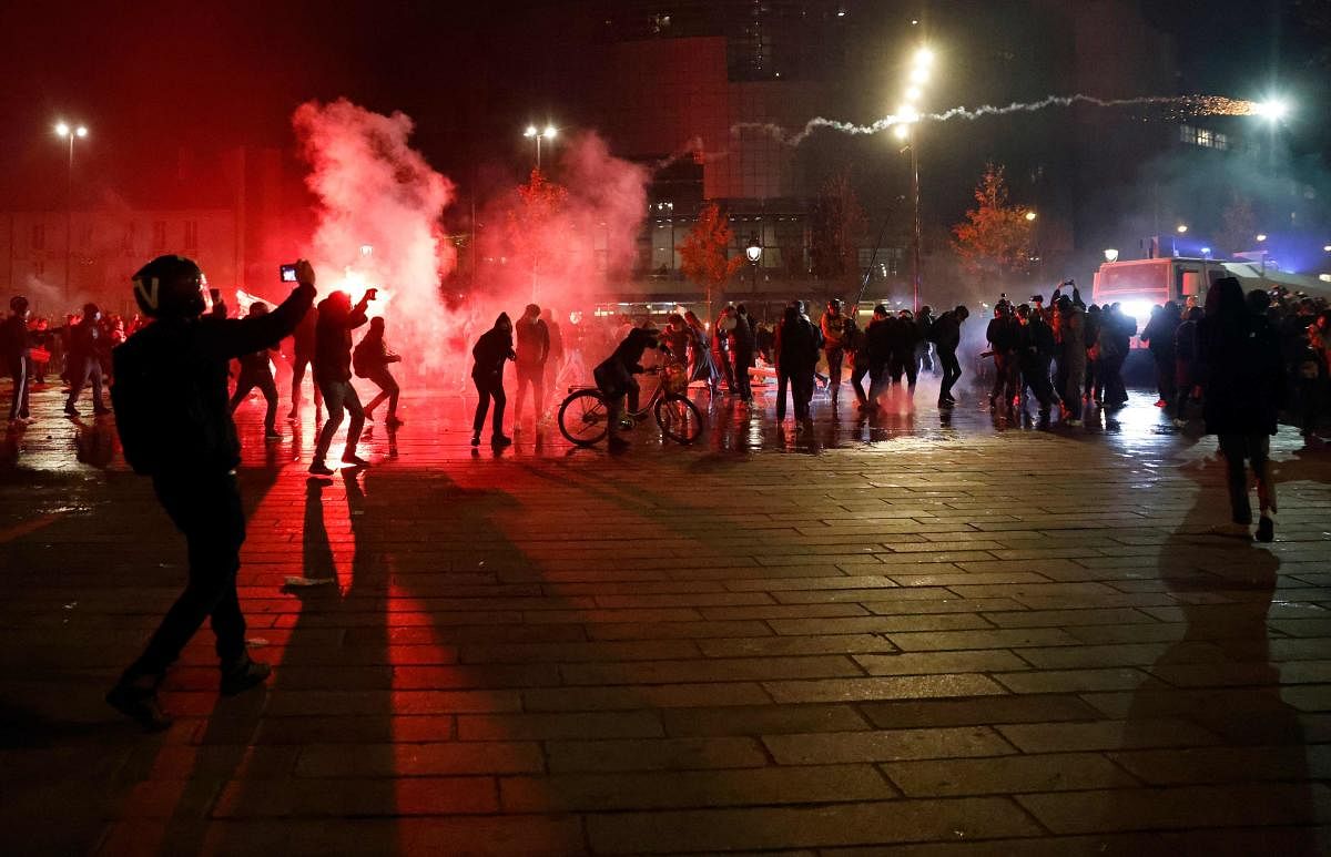 Protesters throw a firework at riot police officers during a demonstration against the 'global security' draft law. Dozens of rallies are planned on November 28 against a new French law that would restrict sharing images of police, only days after the country was shaken by footage showing officers beating and racially abusing a black man. Credit: AFP Photo.