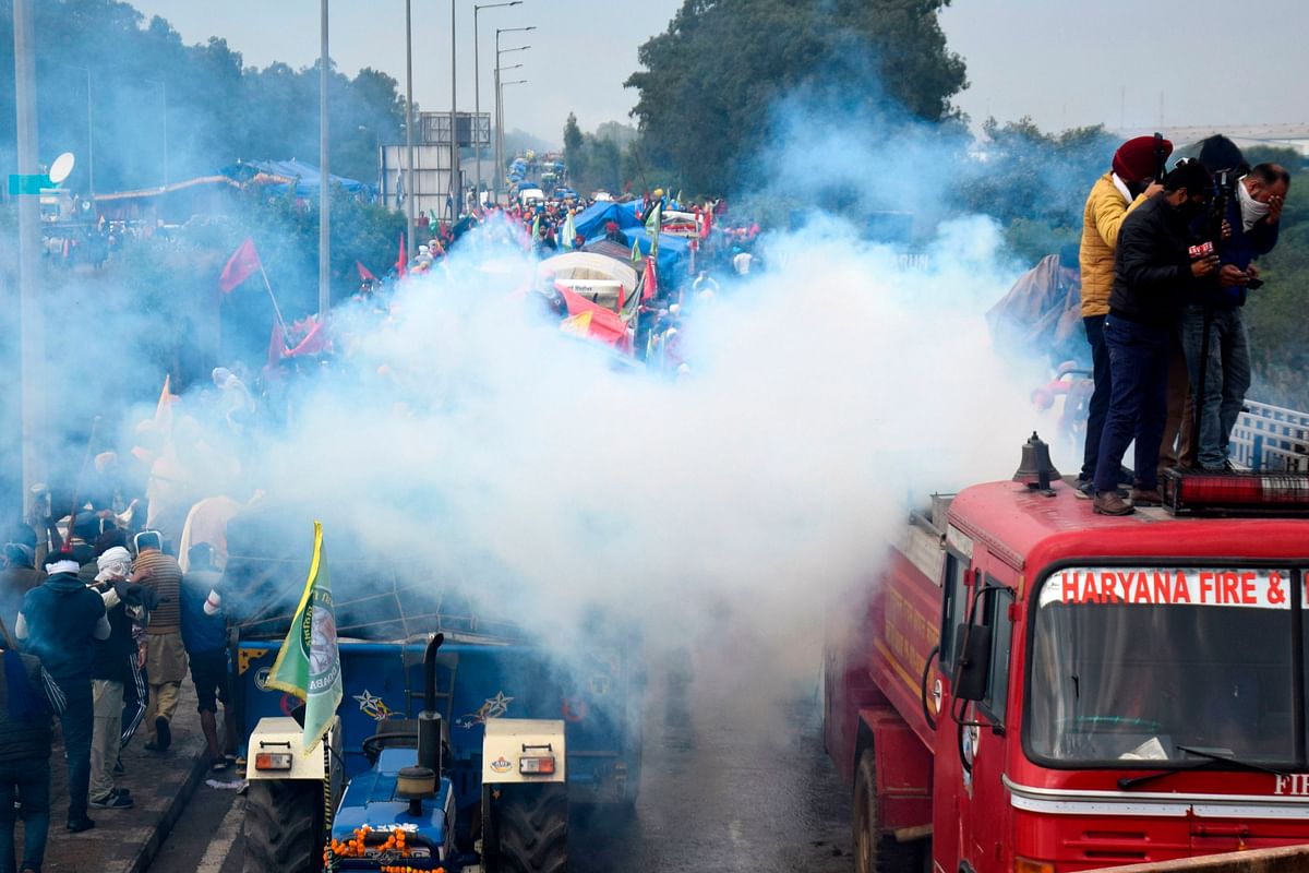 Farmers are seen amid tear gas fired by police