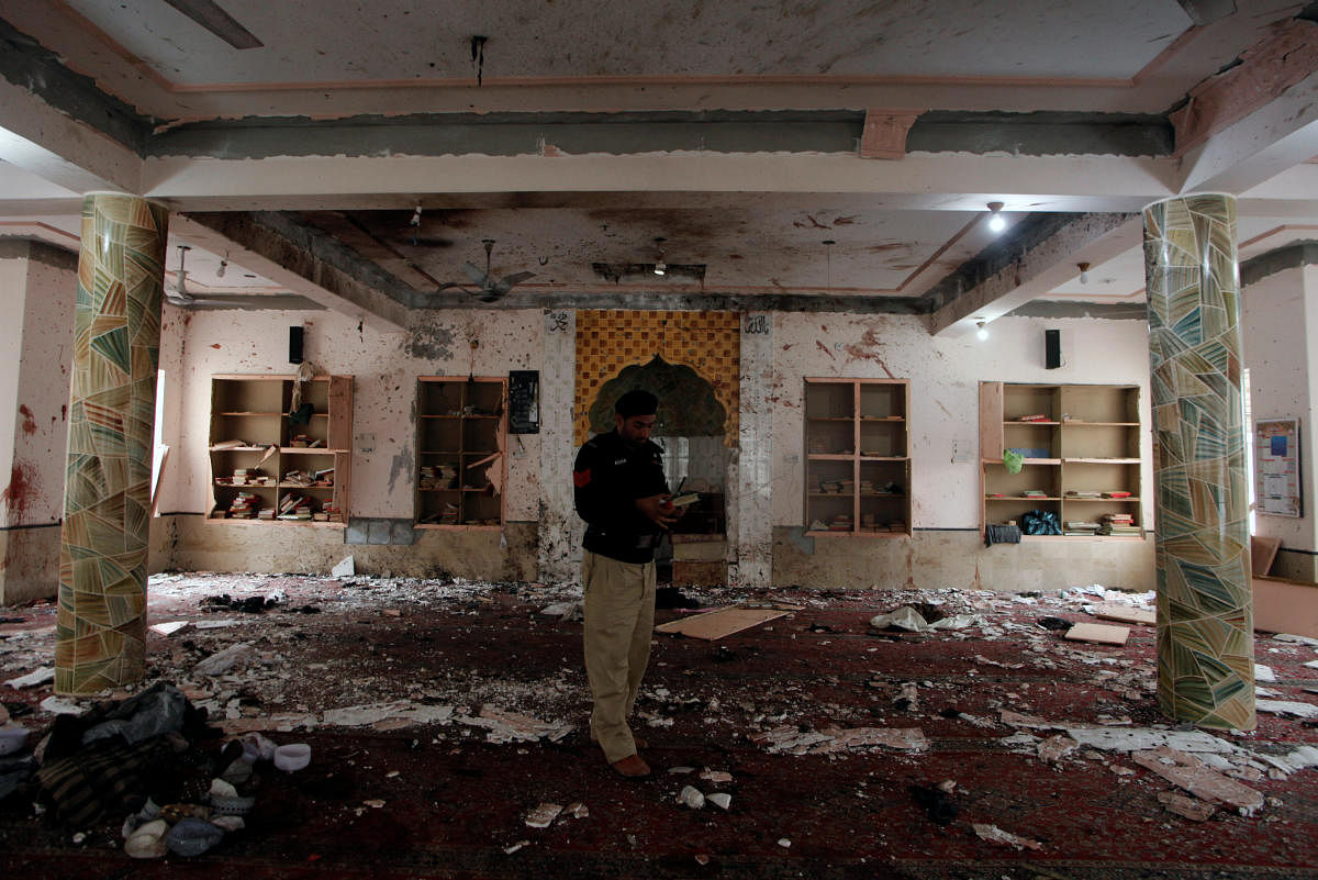 7. Pakistan | A police officer stands amidst the damages as he is surveying and collecting evidence from the site of a bomb blast in a mosque in Quetta, Pakistan. Credit: Reuters Photo