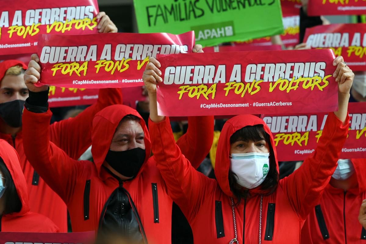 Members of several anti-eviction groups and movements pro the right to a good housing wear the red jumpsuit of the Spanish Netflix hit series La Casa de Papel (Money Heist), as they hold up banners reading