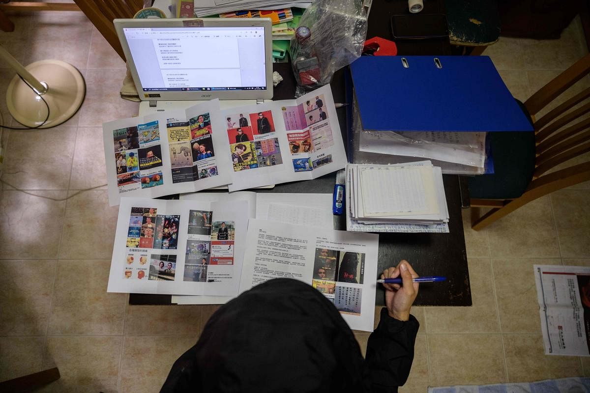 22-year-old pro-democracy activist Hei looks at her DIY newspaper