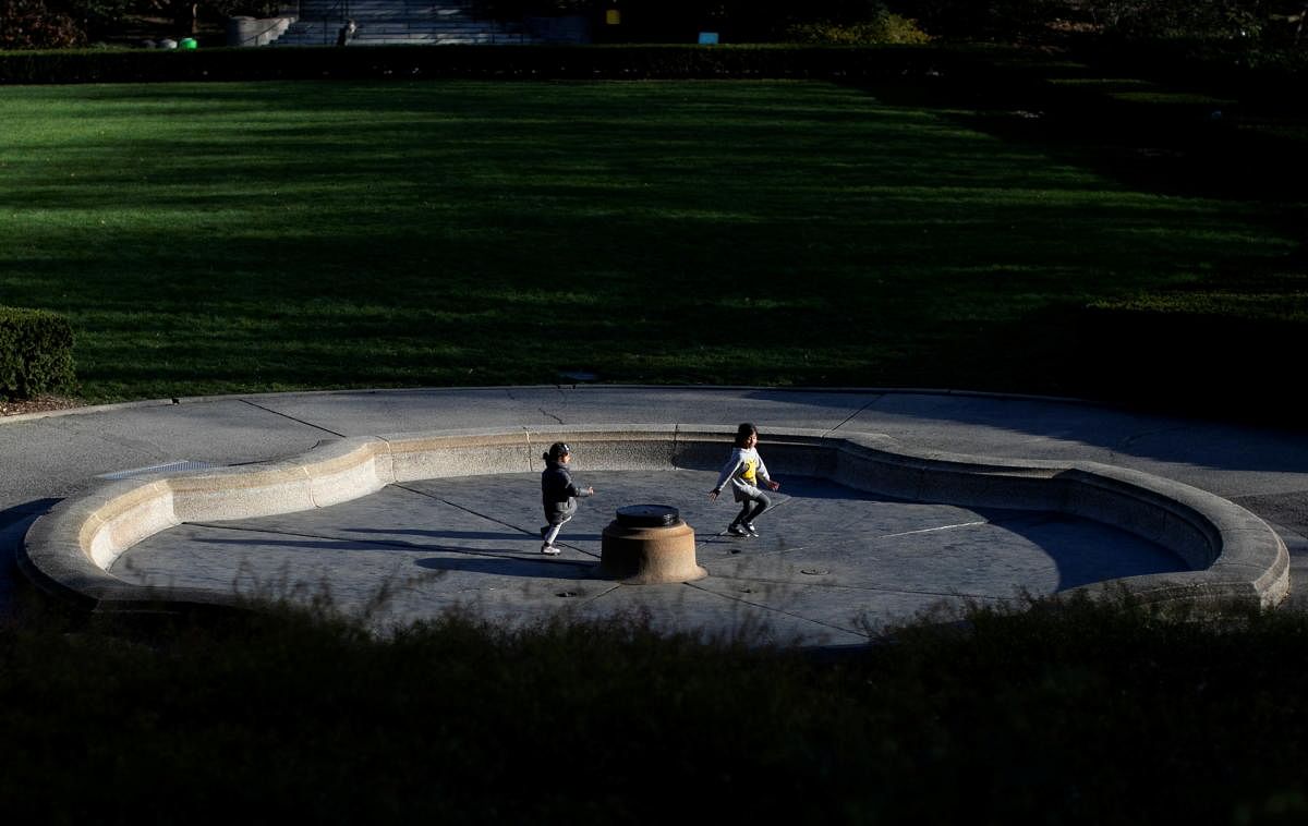 Two children play in a turned off fountain in the mostly empty Conservatory Garden section of Central Park during the COVID-19 pandemic in Manhattan, New York City. Credit: Reuters Photo
