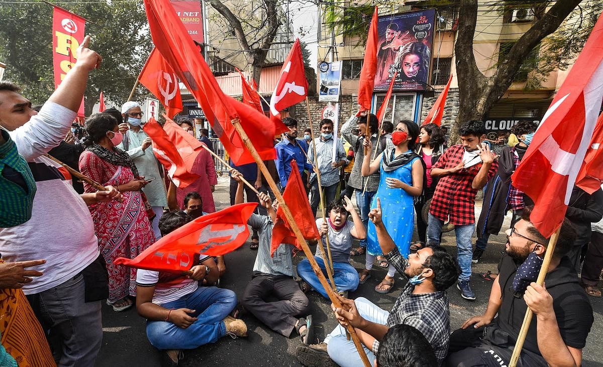 Trade union activists block a road in support of the nationwide strike, called by farmers to press for repeal of the Centre's farm laws, in Kolkata. Credit: PTI Photo.