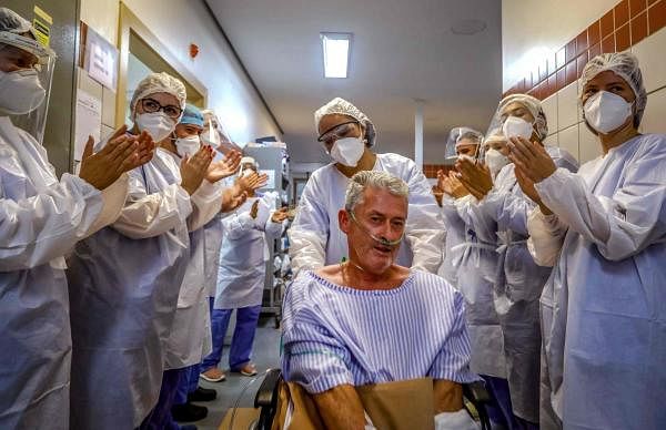 Patient Joao do Nascimento Hendler, 62, is applauded by nurses and doctors as he leaves the Covid-19 Intensive Care Unit at Santa Casa de Misericordia Hospital in Porto Alegre, Brazil. Credit: AFP