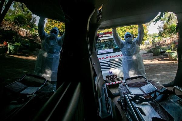 Volunteer Sithu Aung prepares to close the back of an ambulance ahead of the burial of a person suspected of dying from the Covid-19 coronavirus in Yangon. Credit: AFP