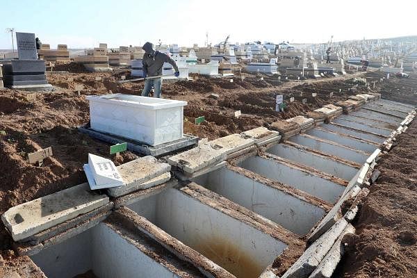 A man backfills a grave in Ortakoy cemetery, the main burial site for people who died during the Covid-19 pandemic in Mamak district of Ankara, Turkey. Credit: AFP