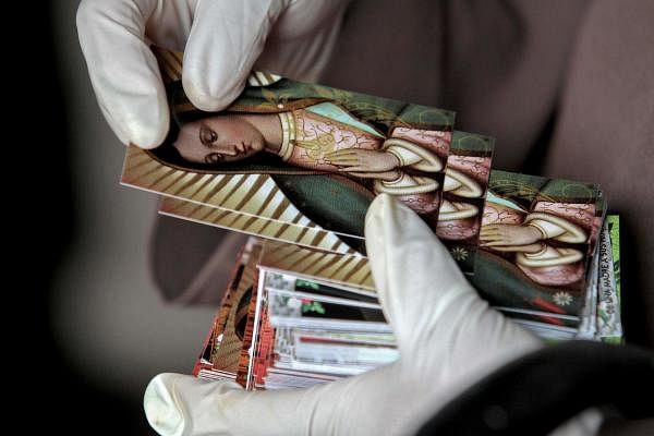 A nun wearing gloves delivers prints with the image of the Virgin of Guadalupe at the temple where it is venerated, on its annual celebration in Guadalajara, Jalisco state, Mexico, in the midst of the Covid-19 pandemic. Credit: AFP