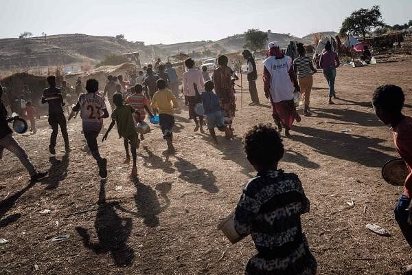 Ethiopian refugee children who fled Ethiopia's Tigray conflict run for a food distribution by Muslim Aid at the Um Raquba refugee camp in Sudan's eastern Gedaref state. Credit: AFP