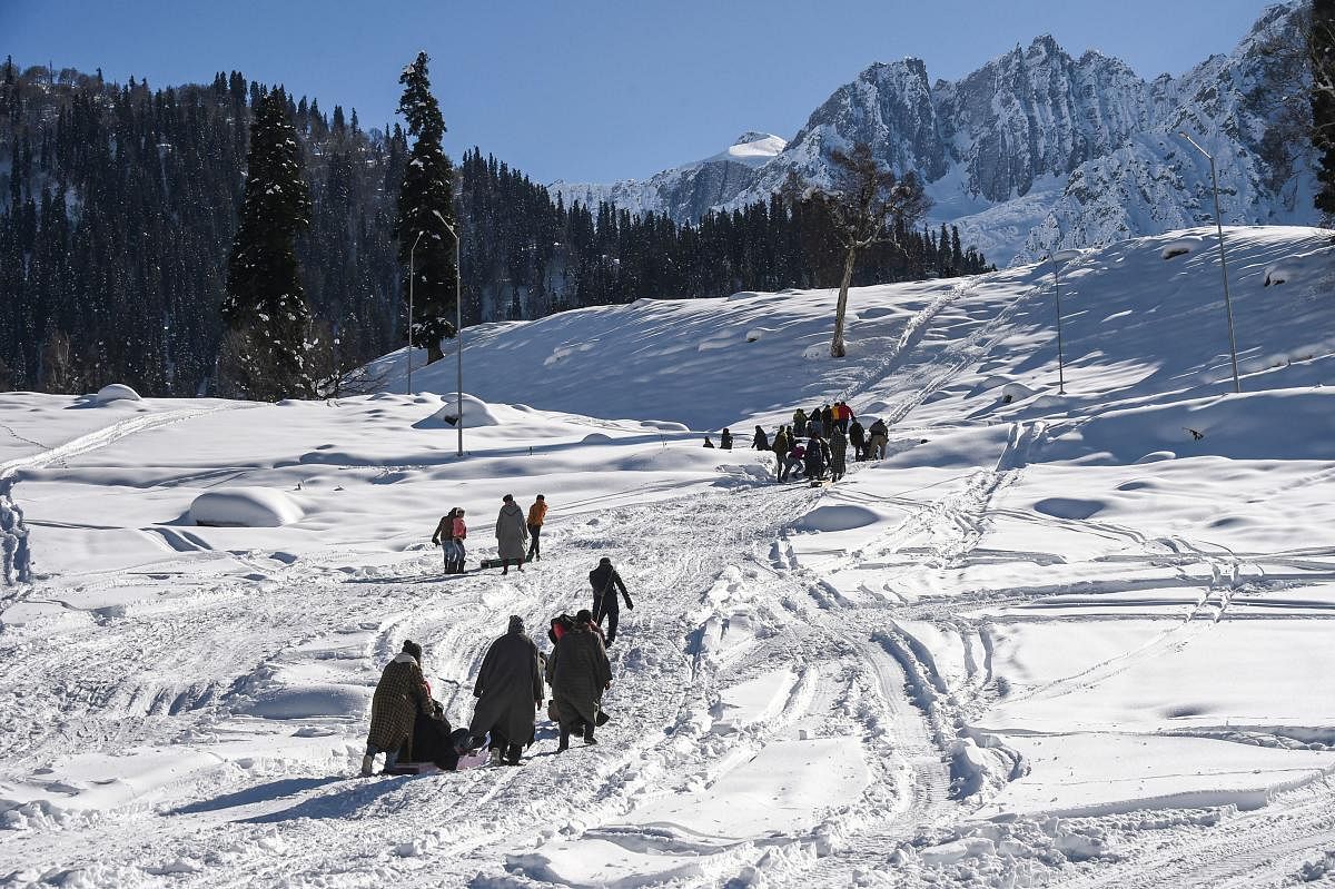 People walk on snow covered slopes of Sonamarg in Ganderbal district of Central Kashmir. Credit: PTI