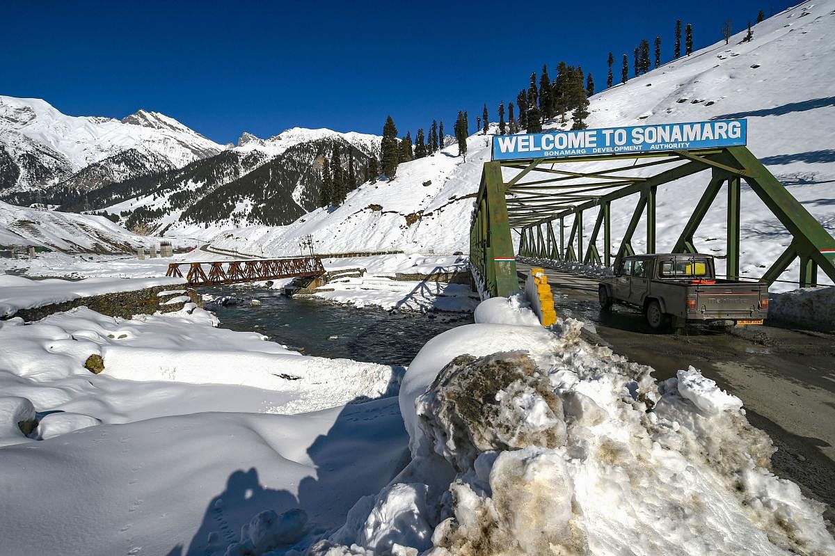 A vehicle moves across a bridge amid the snow-laden area at Sonamarg in Ganderbal district of Central Kashmir. Credit: PTI