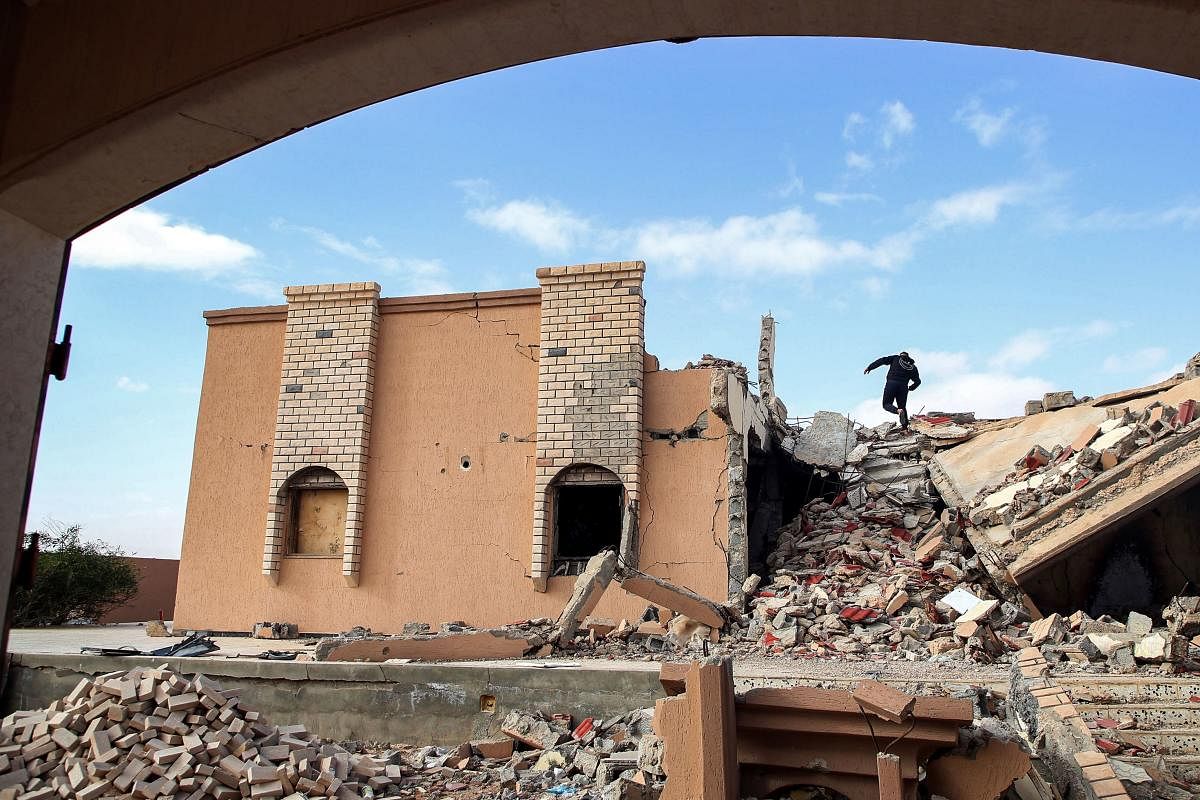 A youth climbs the rubble of a destroyed building in the city of Tawergha, some 200 kilometres (125 miles) east of Libya's capital close to the port city of Misrata. Credit: AFP