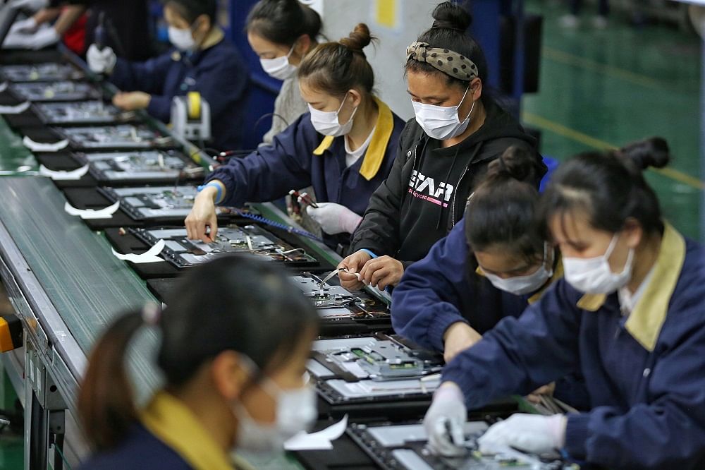 Employees, wearing masks, work on a production line manufacturing display monitors at a TPV factory in Wuhan, Hubei province, the epicentre of the novel coronavirus disease (Covid-19) outbreak in China. Credit: Reuters Photo