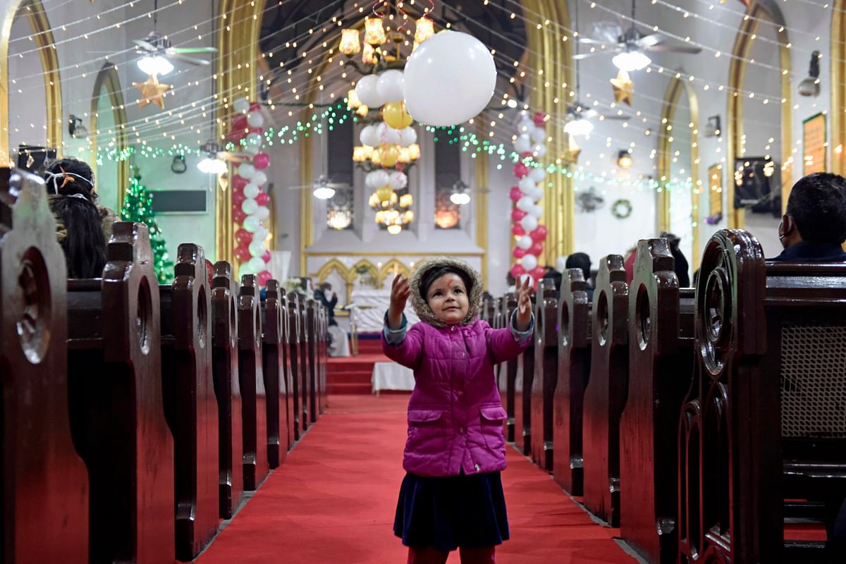 A girl plays with a balloon ahead of the Christmas celebrations at St. Paul church in Amritsar on December 22, 2020. Credit: AFP Photo