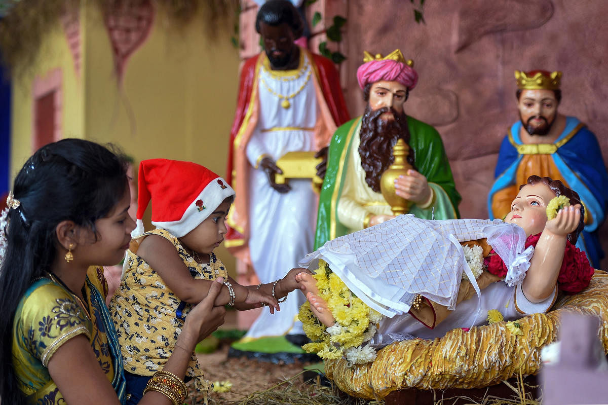 A child touches the feet of baby Jesus statue during Christmas celebrations at Santhome Church, in Chennai, Wednesday, Dec. 25, 2019. Credit: PTI Photo