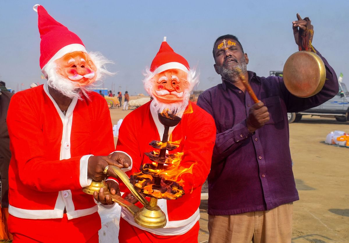 Devotees dressed as Santa Claus perform 'Arti' after taking a holy dip in the Ganga, ahead of Christmas festival, at Sangam in Prayagraj, Wednesday, Dec. 23, 2020. Credit: PTI Photo