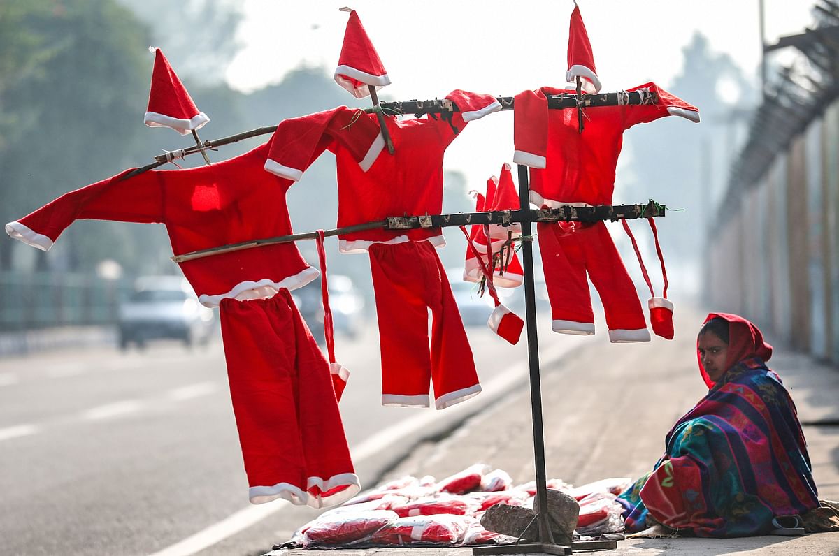 A roadside vendor waits for customers to sell Santa Claus costumes and masks, ahead of Christmas, in Jammu, Wednesday, Dec. 23, 2020. Credit: PTI Photo