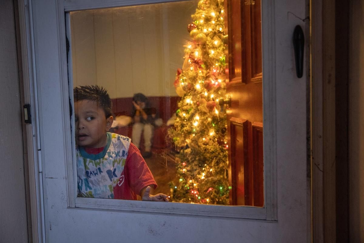 Mario, 7, looks from his family's home where 8 out of 10 family members are Covid-19 positive in Stamford, Connecticut. Credit: AFP