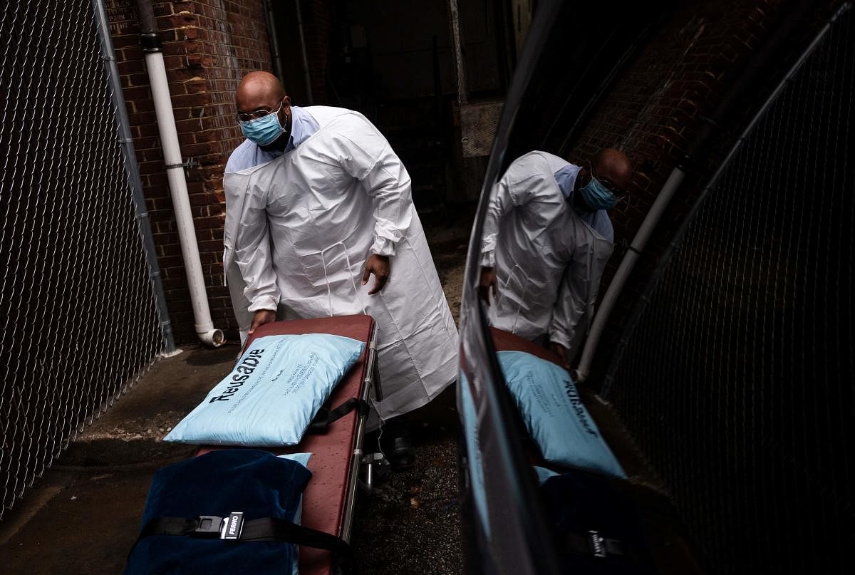 Maryland Cremation Services transporter Reggie Elliott folds up a spare gurney after bringing the remains of a Covid-19 victim to his van from the hospital's morgue in Baltimore, Maryland. Credit: AFP