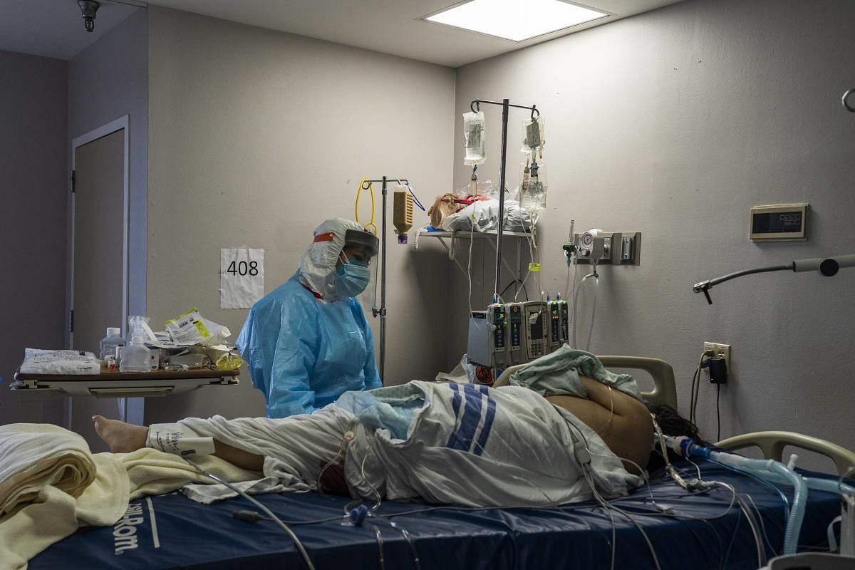 A medical staff member stands by a patient in the Covid-19 intensive care unit (ICU) on Christmas Eve at the United Memorial Medical Center in Houston, Texas. Credit: AFP