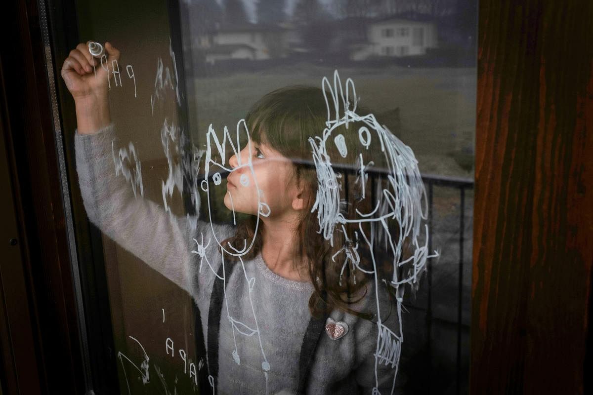 Bianca Toniolo, Marzio Toniolo's daughter, draws on her bedroom's window on Christmas Eve in San Fiorano, Italy. Credit: Reuters