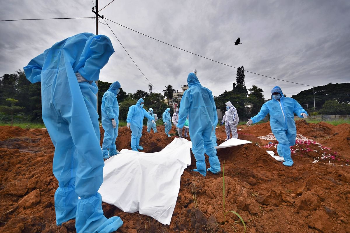 Of lives lostt | Volunteers bury a Covid-19 patient at a cemetery in Bengaluru. Even as the number of Covid-19 deaths in the state saw a dramatic decline in recent days, Bengaluru Urban stood at the far end of the spectrum. Credit: DH Photo/ Pushkar V