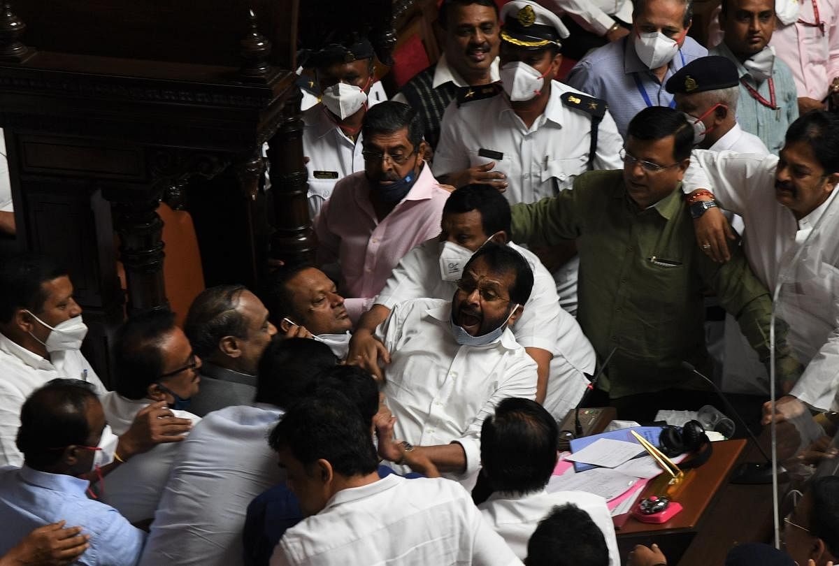 Never seen before ruckus in the Karnataka Legislative Council | The Council had witnessed high drama with BJP-JDS and Congress members hurling abuses and pushing each other and the Deputy Chairman being pulled down from the Chairman's seat over a row pertaining to the no-confidence motion. Pandemonium ensued between BJP and Congress leaders over the chairman post in the Karnataka Legislative Council meet. Congress MLCs heckled and pushed Deputy Chairman of the Legislative Council, SL Dharme Gowda, from his seat. Credit: DH Photo/ BH Shivakumar