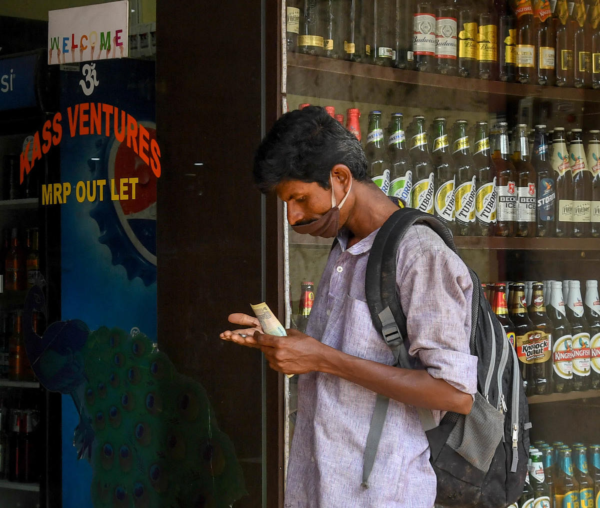 A drop to savour | A customer stands in queue to buy liquor from a shop as the Karnataka government reopened liquor shops and permited sale of alcohol in a limited manner after over 40 days of lockdown. Credit: DH Photo/ B H Shivakumar